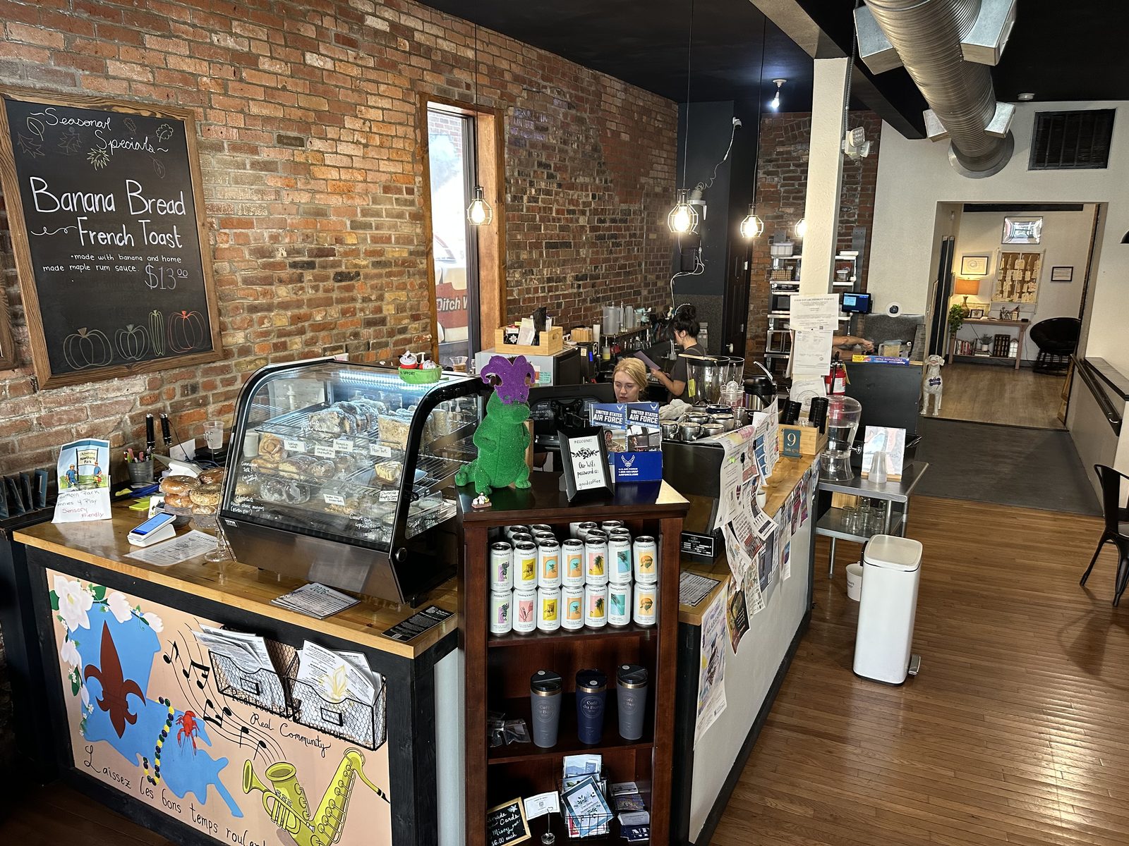 Inside Café Du Burg — exposed brick, the bakery case, and the counter