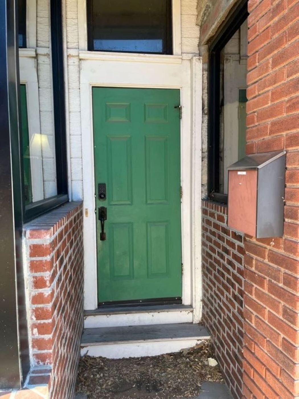 Street-level green entry door to the apartment
